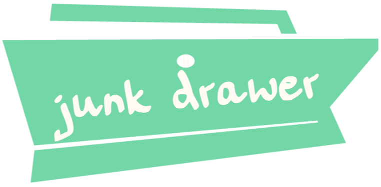 Tealish colored, half-opened drawer with the words junk drawer handwritten on the front and a stylized H as the drawer pull